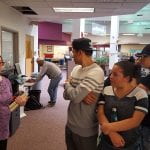 woman explaining to students with copier in background